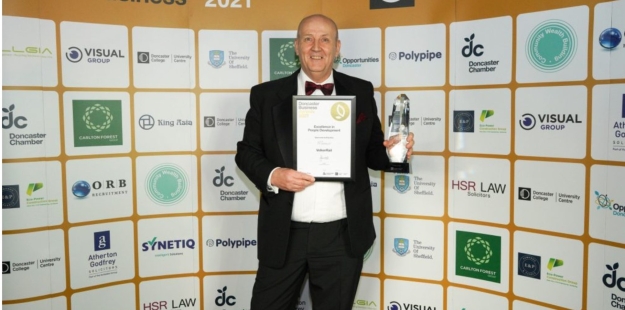Man in a tux collecting an award