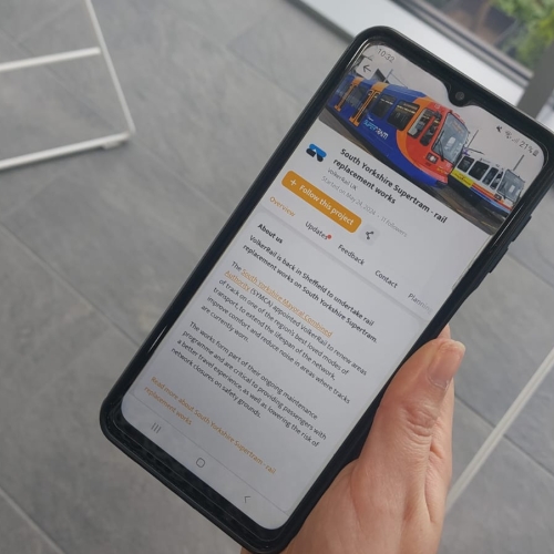 Someone holding a phone showing the community app for south Yorkshire Supertram