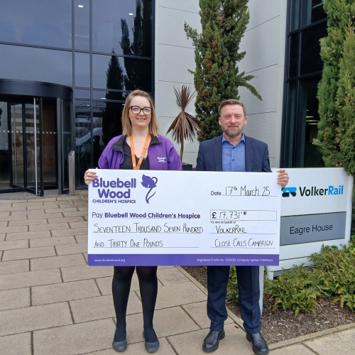 man and women holding a large cheque
