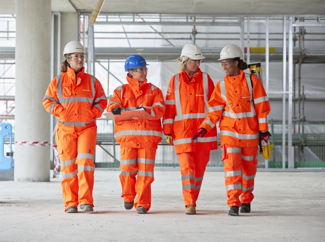 Four women in high vis walking on a construction site