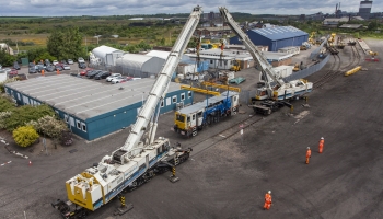 image of two kirow cranes picking up a beaver tamper