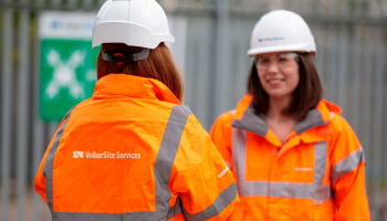 Women with her back to the camera and orange PPE with a VolkerSite Services logo on