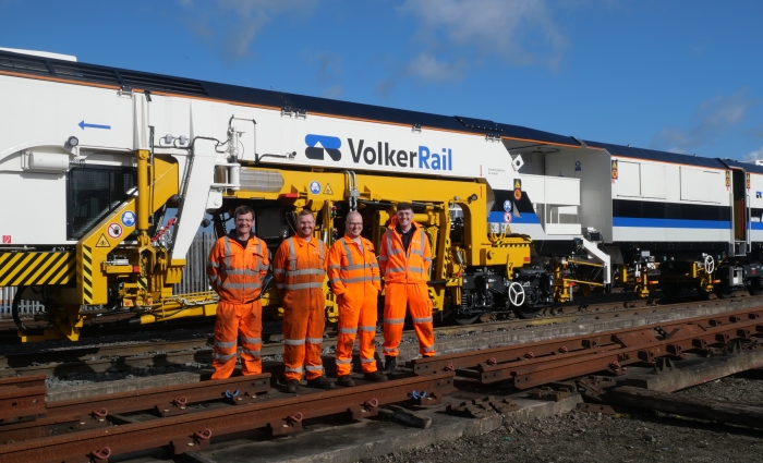 A group photo in front of a Matisa tamper