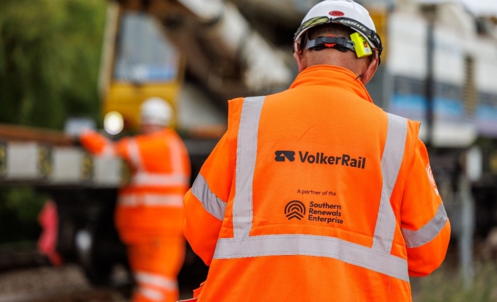An operative wearing orange PPE with VolkerRail logo on the back
