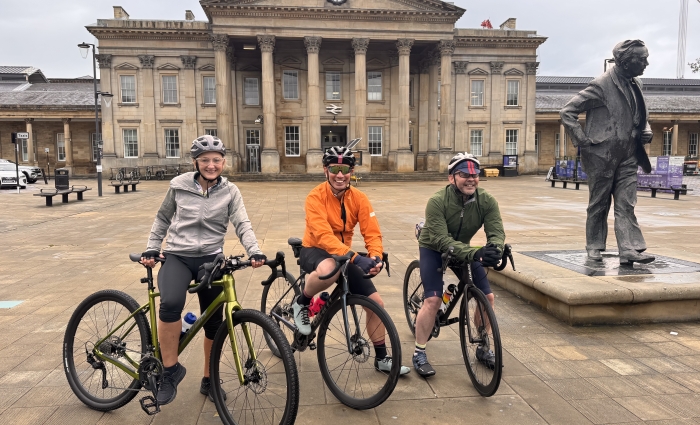 three cyclists outside a grand building