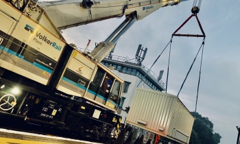 A Kirow 1200 crane lifting a third rail booster transformer