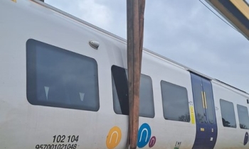 A passenger train being rerailed using a Kirow crane