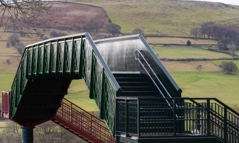 A new footbridge with green hills in the background