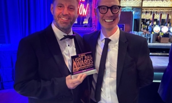 two people holding the global light rail award