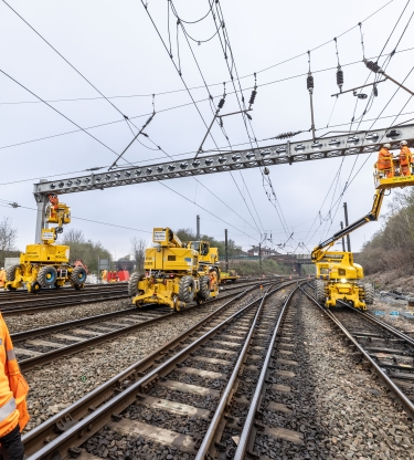 Rail operative looking up at an overhead line gantry being installed by VolkerRail using MEWPS and road rail vehicles on the Transpennine route upgrade project 