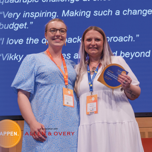 Two women smiling after receiving an award