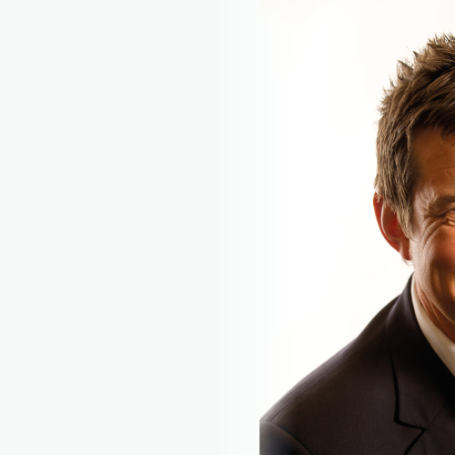 A man in a suit smiling