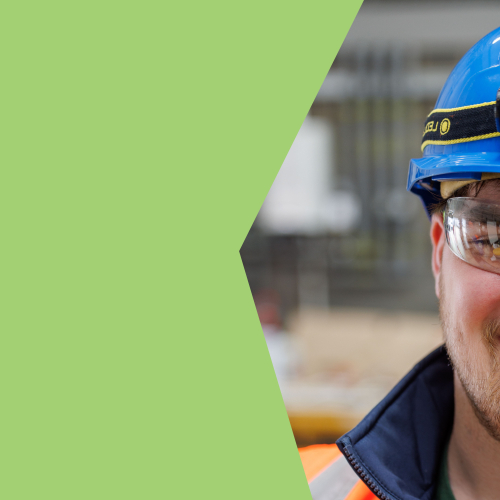 A young man in orange PPE and blue hard hat smiling