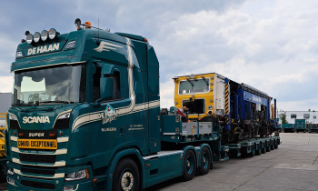 A Beaver tamper being transported on a back of a lorry