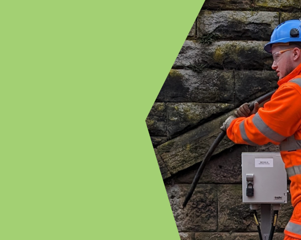 A man in orange PPE moving a telecoms cable